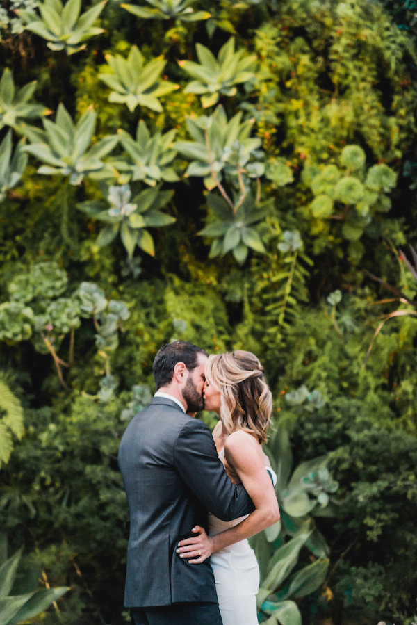 Smog Shoppe Succulent Wall wedding couple kissing.