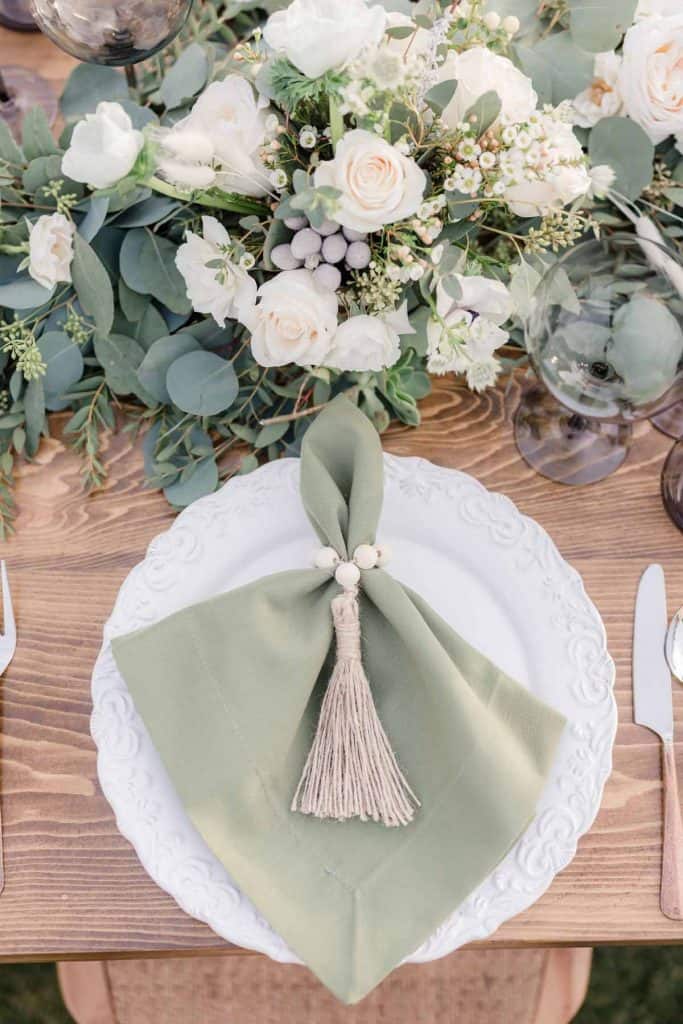 White Floral Centerpiece with Sage Green Napkin