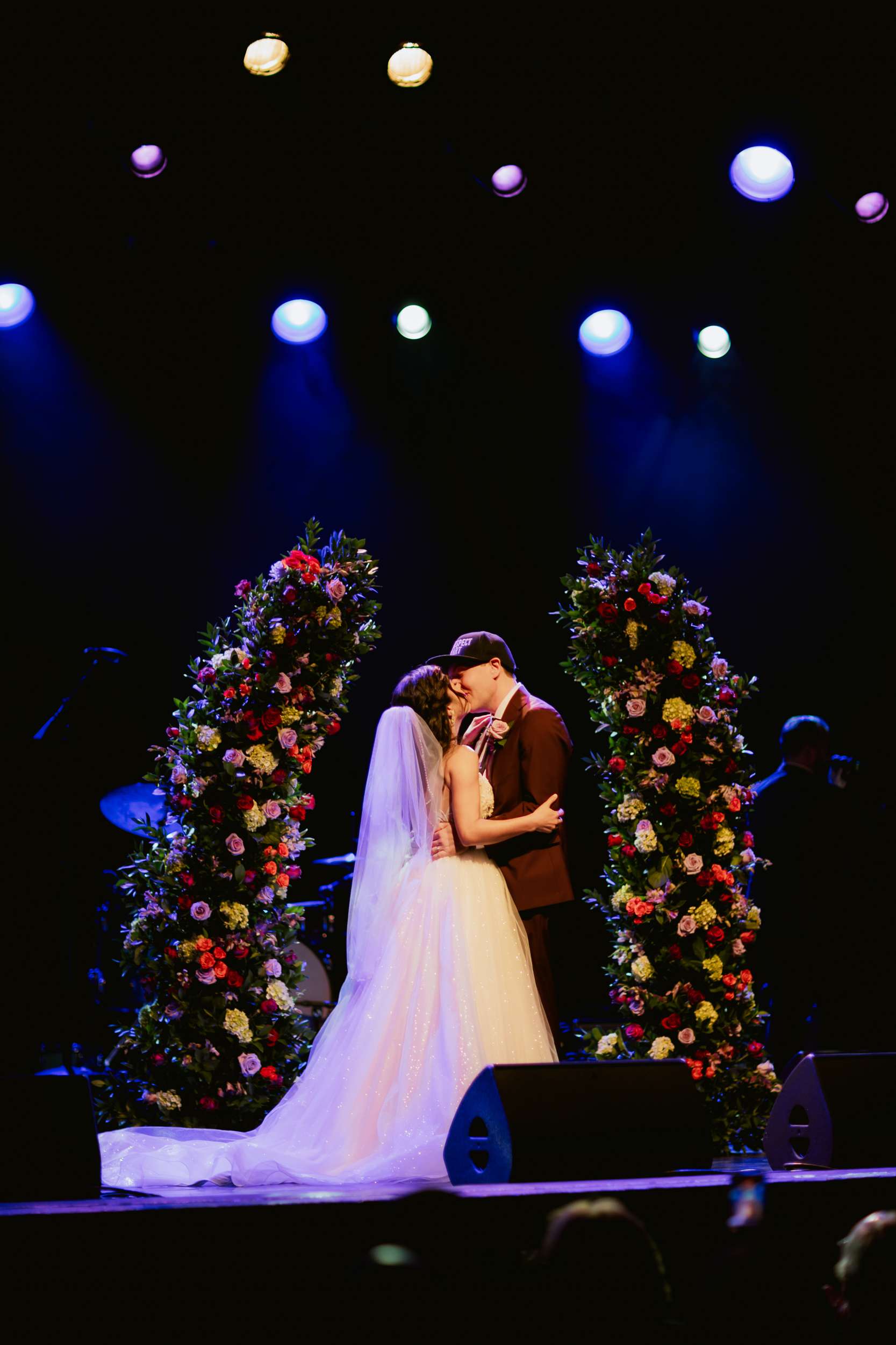 bride and groom at their wedding with flower towers behind them